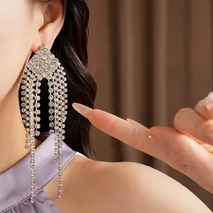 Detailed close-up of elegant silver needle earrings with shimmering crystal tassels