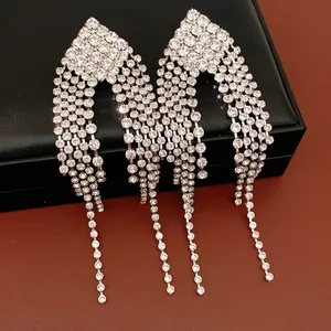 Close-up of elegant rhinestone diamond-shaped fringe earrings displayed on a black jewelry box