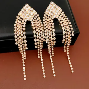 Detailed macro shot of elegant gold-toned rhinestone tassel fringe drop earrings