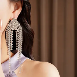 Elegant close-up showing long silver needle rhinestone tassel earrings worn on ear