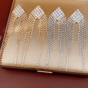 Close-up of sparkling rhinestone tassel earrings in gold and silver finish