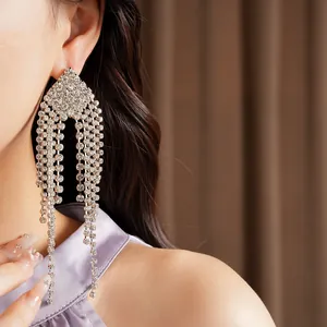 Close-up detail of luxurious silver rhinestone tassel earrings in a diamond shape design.