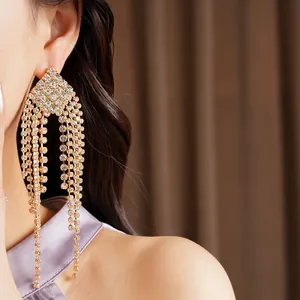 Close-up shot of elegant silver rhinestone diamond-shaped tassel earrings on model