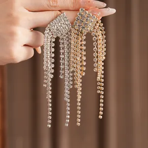 Macro view of luxury sparkling rhinestone diamond-shaped long tassel drop earrings