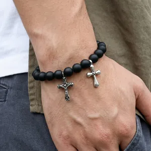 Detailaufnahme von mattschwarzen Perlenarmband mit silbernen Kreuzanhängern für Herren