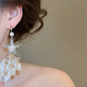 Detail view of elegant starfish tassel earrings with drop pearls and silver finish
