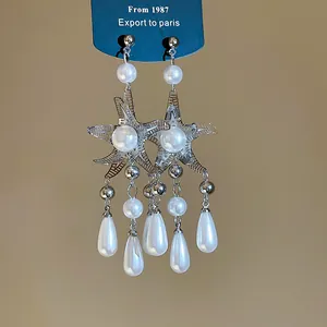 Close-up of starfish tassel earrings with pearls and water drop pendants.