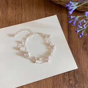 Nahaufnahme eines eleganten mehrlagigen Armbands mit Lavendelperlen und Silberperlen.