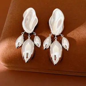 Orecchini a forma di onda in argento con pendenti a goccia su velluto marrone
