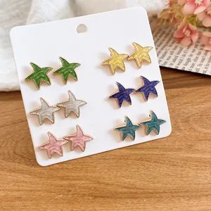 Vista detallada de seis pares de pendientes de estrella de colores con elegante diseño de esmalte.