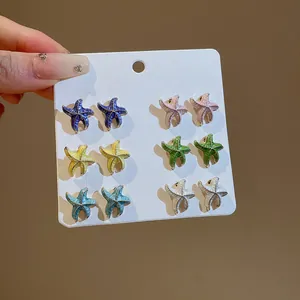 Detalle de pendientes de estrella de mar en esmalte de seis vibrantes colores de verano