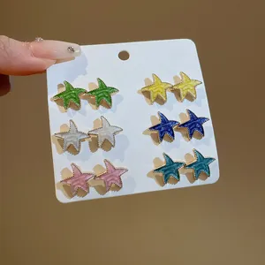 Primer plano de un juego de 6 pares de pendientes de estrella de mar de esmalte