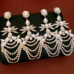 Close-up view of elegant geometric rhinestone fringe earrings with teardrop crystals.