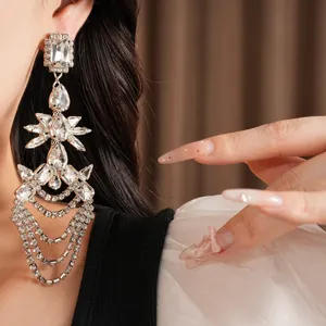 Close-up of exaggerated geometric tassel earrings with glittering rhinestones