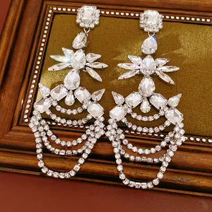 Detail shot of sparkling geometric rhinestone tassel earrings with a silver-tone finish.