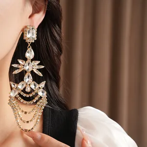 Macro view of luxurious crystal tassel earring with geometric teardrop shapes on model