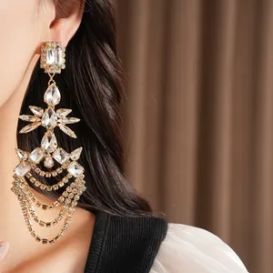 Detail view of silver drop tassel earrings with sparkling geometric crystals on a model