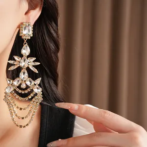 Detail of luxury crystal tassel earrings with teardrop and geometric rhinestones.