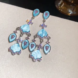 Vue détaillée de boucles d'oreilles pendantes en zircon bleu et plaqué or 18 carats