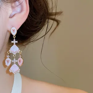 Vue rapprochée détaillée d'élégantes boucles d'oreilles éventail plaquées or 18 carats
