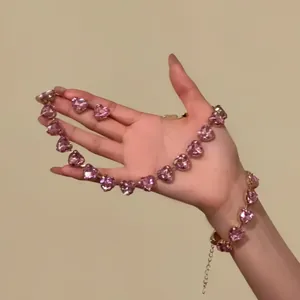 Close-up of pink crystal heart jewelry set held in hand