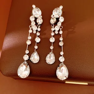 Detailed close-up of silver-tone teardrop tassel earrings with sparkling rhinestones