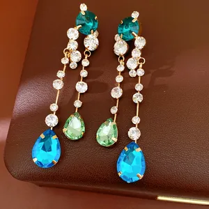 Detail of elegant dangling earrings featuring multi-colored crystal teardrop charms.