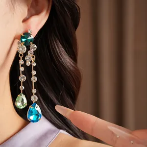 Detailed view of elegant gold-tone dangling earrings with colorful teardrop stones.