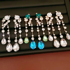 Detail view of colorful crystal drop earrings with teardrop pendants on black tray