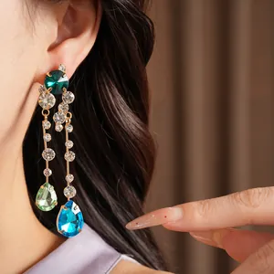 Detailed macro view of elegant rhinestone teardrop dangling earrings on a model's ear