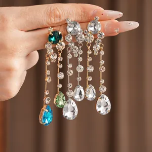 Detailed view of dangling earrings with sparkling rhinestones and colorful teardrop crystals