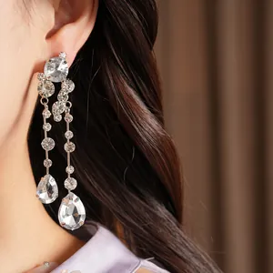 Detailed view of elegant dangling earrings featuring round and teardrop-shaped clear rhinestones