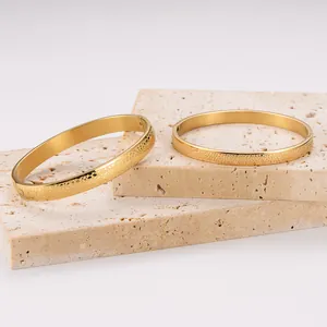 Macro view of 18k gold plated stainless steel bangles featuring unique hammered texture