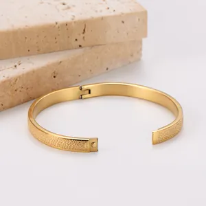 Detail shot of 18k gold plated stainless steel bangle with textured spotted finish