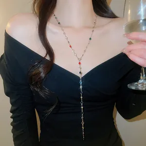 Gros plan élégant d'un collier en Y avec cristaux colorés porté par un mannequin en robe