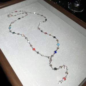 Vue détaillée d'un collier en Y avec perles de cristal colorées sur un plateau à bijoux