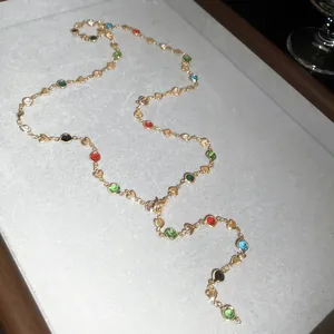 Vue détaillée d'un collier en Y avec perles de cristal colorées et breloques cœur dorées