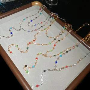 Gros plan de colliers en Y perlés de cristaux colorés sur un plateau à bijoux