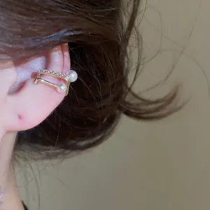 Detailed macro shot of an elegant gold ear cuff featuring zircon stones and pearls