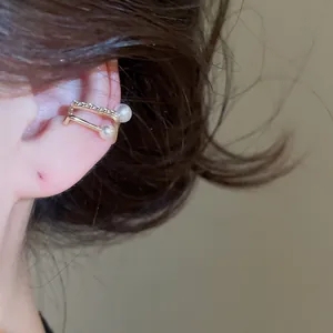 Detailed view of elegant double-row gold ear cuff with zircon and pearls on ear