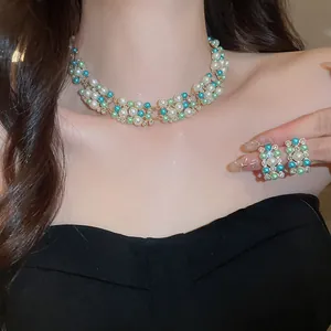 Detailed view of French vintage pearl and rhinestone necklace and earring set worn by a model