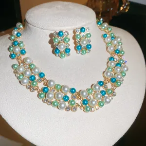 Detailed view of teal and white pearl necklace and matching earrings set.