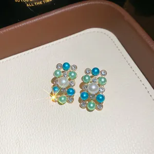 Close-up of vintage French style geometric earrings with blue pearls and rhinestones