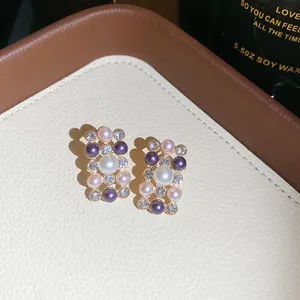 Close-up view of elegant French vintage pearl and rhinestone stud earrings on tray