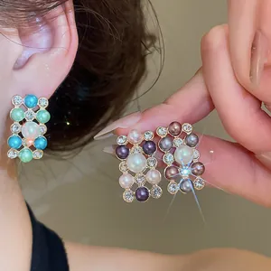 Close-up of elegant French vintage faux pearl and rhinestone beaded stud earrings on ear