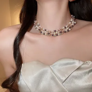 Detailed shot of a French vintage layered pearl and rhinestone necklace on a model
