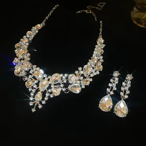 Detailed view of elegant rhinestone water drop necklace and earring set on black background.