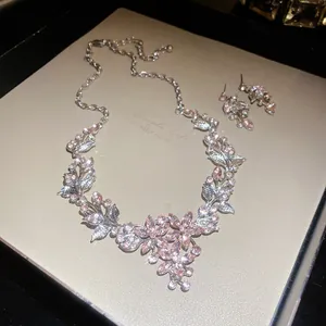 Detail showing elegant pink rhinestone flower necklace and matching earrings on display