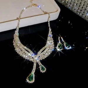Close-up of glamorous green teardrop pendant necklace and earring set with shiny rhinestones