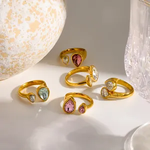 Dettaglio di anelli in acciaio inossidabile placcati oro 18k con zirconi a goccia colorati.